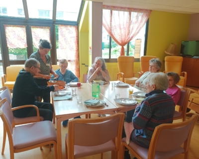 Des habitants de la Maison réunis autour d'une table pour partager un repas